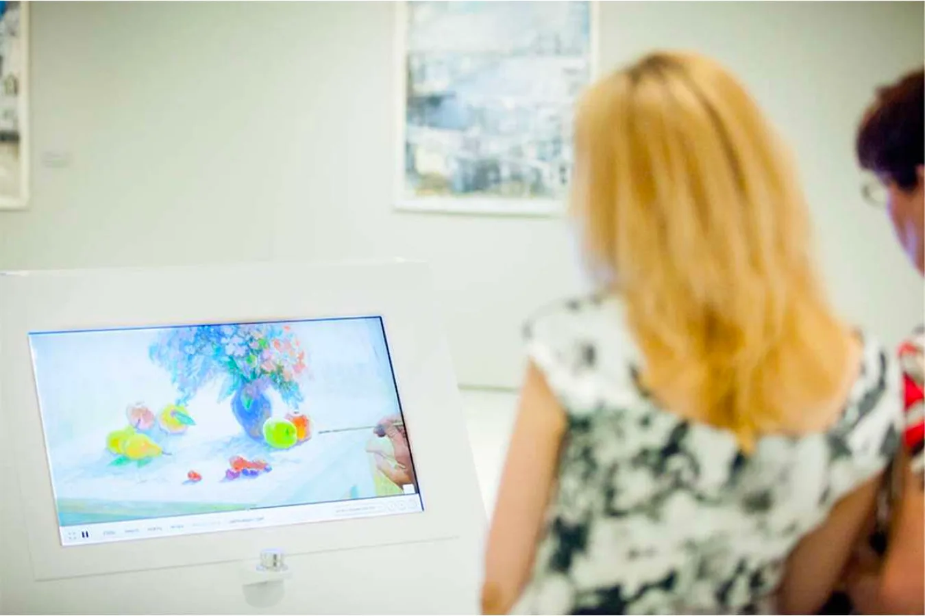Visitors looking at the painting process installation in the museum space.